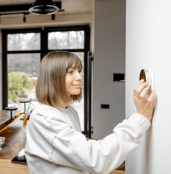 woman adjust thermostat 567x576 woman adjust thermostat 567x576