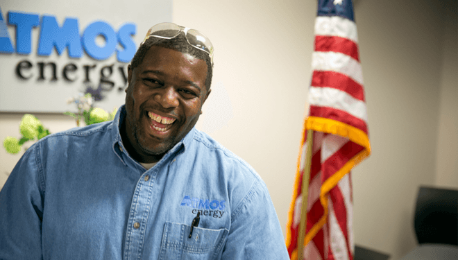 Atmos Energy employee standing in front of an American flag