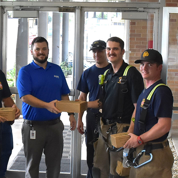 Atmos employee presenting care package to first responders